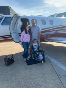 Suresh Narayanan posing with his family outside of a private plane